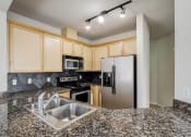 Thumbnail 22 of 52 - a kitchen with granite counter tops and a stainless steel refrigerator  at Delano, Redmond, WA 98052