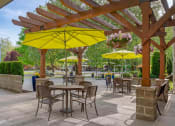 Thumbnail 12 of 52 - a patio with tables and chairs and umbrellas at Delano, Redmond