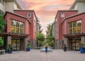 Thumbnail 11 of 52 - the courtyard of a condo building with a patio and potted plants at Delano, Redmond Washington