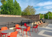 Thumbnail 14 of 52 - a patio with tables and chairs and a brick wall at Delano, Washington, 98052