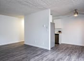 Thumbnail 22 of 60 - Living room and kitchen with white walls and wood floors at The Ridge at Bellevue, Washington