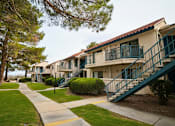 Thumbnail 15 of 35 - A row of apartment buildings with green railings and staircases.