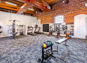 Thumbnail 90 of 98 - A gym with a variety of equipment including weights and exercise machines.