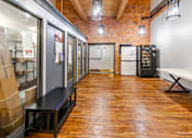 Thumbnail 92 of 98 - A long hallway with a bench and a fridge.