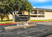 Thumbnail 1 of 11 - A sign for Brentwood Timberlane Apartments is displayed in front of a building.