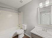 Thumbnail 16 of 28 - A white toilet sits next to a white sink in a bathroom.