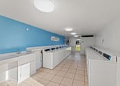 Thumbnail 17 of 28 - A laundromat with rows of washers and dryers.