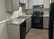 Thumbnail 13 of 27 - a kitchen with white cabinets and black appliances