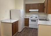 Thumbnail 15 of 27 - an empty kitchen with white appliances and wooden floors