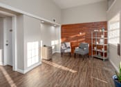 Thumbnail 1 of 28 - A room with a wooden floor and a wooden wall with a chair and a table in it.
