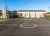 Thumbnail 27 of 28 - A basketball court is located in the middle of a parking lot.