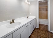 Thumbnail 2 of 22 - A bathroom with a white sink and a white counter top.