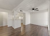Thumbnail 15 of 22 - A room with a ceiling fan and wooden floors.