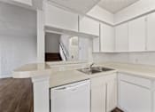 Thumbnail 18 of 22 - A white kitchen with a dishwasher and sink.