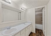 Thumbnail 14 of 22 - A bathroom with a white sink and a mirror.