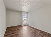 Thumbnail 10 of 22 - A room with wooden floors and a window with bars on it.