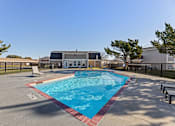 Thumbnail 19 of 28 - A small pool with a red border and a building in the background.