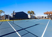 Thumbnail 20 of 22 - A tennis court with a blue surface and white lines.