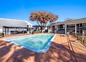 Thumbnail 19 of 22 - A small pool surrounded by a black fence and a tree with brown leaves.