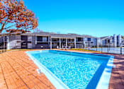 Thumbnail 5 of 22 - A swimming pool surrounded by a fence and trees.