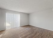 Thumbnail 24 of 28 - A room with wooden flooring and a window with blinds.