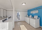 Thumbnail 22 of 22 - A laundromat with washers and dryers and a sign that says "Tailor Room Rules".