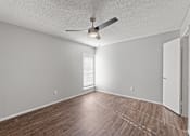 Thumbnail 20 of 28 - A room with a ceiling fan and wooden flooring.