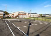 Thumbnail 28 of 28 - A parking lot with a building in the background.
