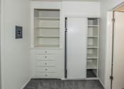 Thumbnail 19 of 27 - A white closet with drawers and shelves is open.