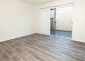 Thumbnail 23 of 27 - A room with a wooden floor and a sliding glass door.