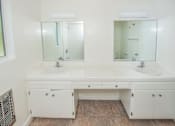 Thumbnail 20 of 27 - A white bathroom vanity with two sinks and two mirrors.