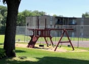 Thumbnail 20 of 23 - a swing set in a park next to a tree