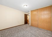 Thumbnail 10 of 11 - A room with a grey carpet and wooden wardrobes.