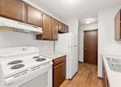 Thumbnail 5 of 11 - A kitchen with white appliances and wooden cabinets.