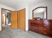 Thumbnail 13 of 16 - A bedroom with a dresser and mirror.
