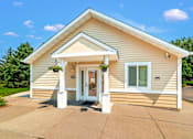 Thumbnail 3 of 16 - A small house with a white door and windows.