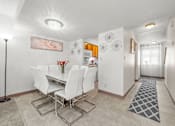 Thumbnail 10 of 16 - A dining room with a white table and chairs.