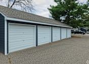 Thumbnail 8 of 8 - A row of three garage doors in a blue building.