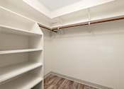 Thumbnail 17 of 27 - Empty white shelves in a room with wooden floors and white walls.