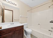 Thumbnail 15 of 15 - A bathroom with a white sink, toilet, and bathtub.