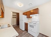 Thumbnail 10 of 15 - A kitchen with white appliances and wooden cabinets.