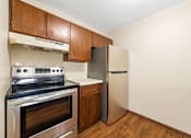 Thumbnail 7 of 15 - A kitchen with a stove, oven, and refrigerator.