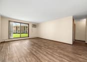 Thumbnail 12 of 15 - A room with wooden flooring and a sliding glass door leading to a balcony.