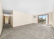 Thumbnail 9 of 15 - A room with a grey carpet and a window overlooking a balcony.