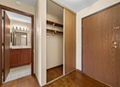 Thumbnail 5 of 15 - A wooden door is open to a bathroom with a mirror.
