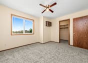 Thumbnail 12 of 15 - A room with a ceiling fan and a window overlooking a landscape.