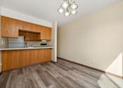 Thumbnail 6 of 15 - A kitchen with wooden cabinets and a refrigerator.