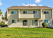 Thumbnail 11 of 14 - A two-story house with a brown roof and beige siding.