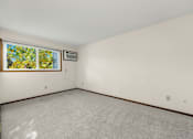 Thumbnail 8 of 14 - A room with a window and a carpeted floor.