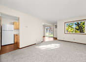 Thumbnail 6 of 14 - A white refrigerator is in a kitchen with wood cabinets.
